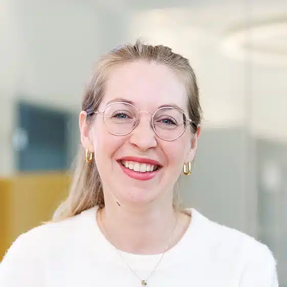 Lachendes Porträt einer Frau mit Brille.